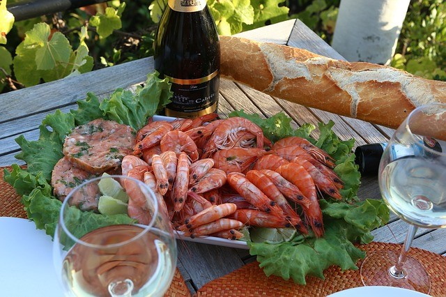 Platter of shrimp on a table with wine